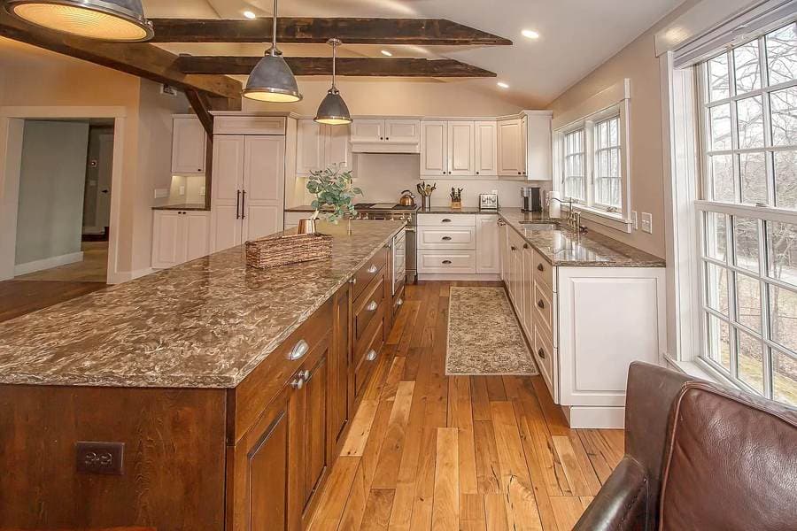 The same beamed kitchen fully restored with hardwood floors and granite island